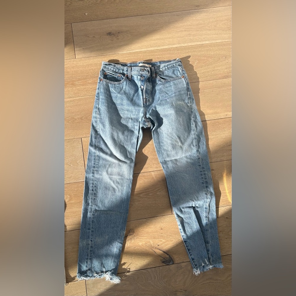 Cropped frayed light wash Levi jeans.